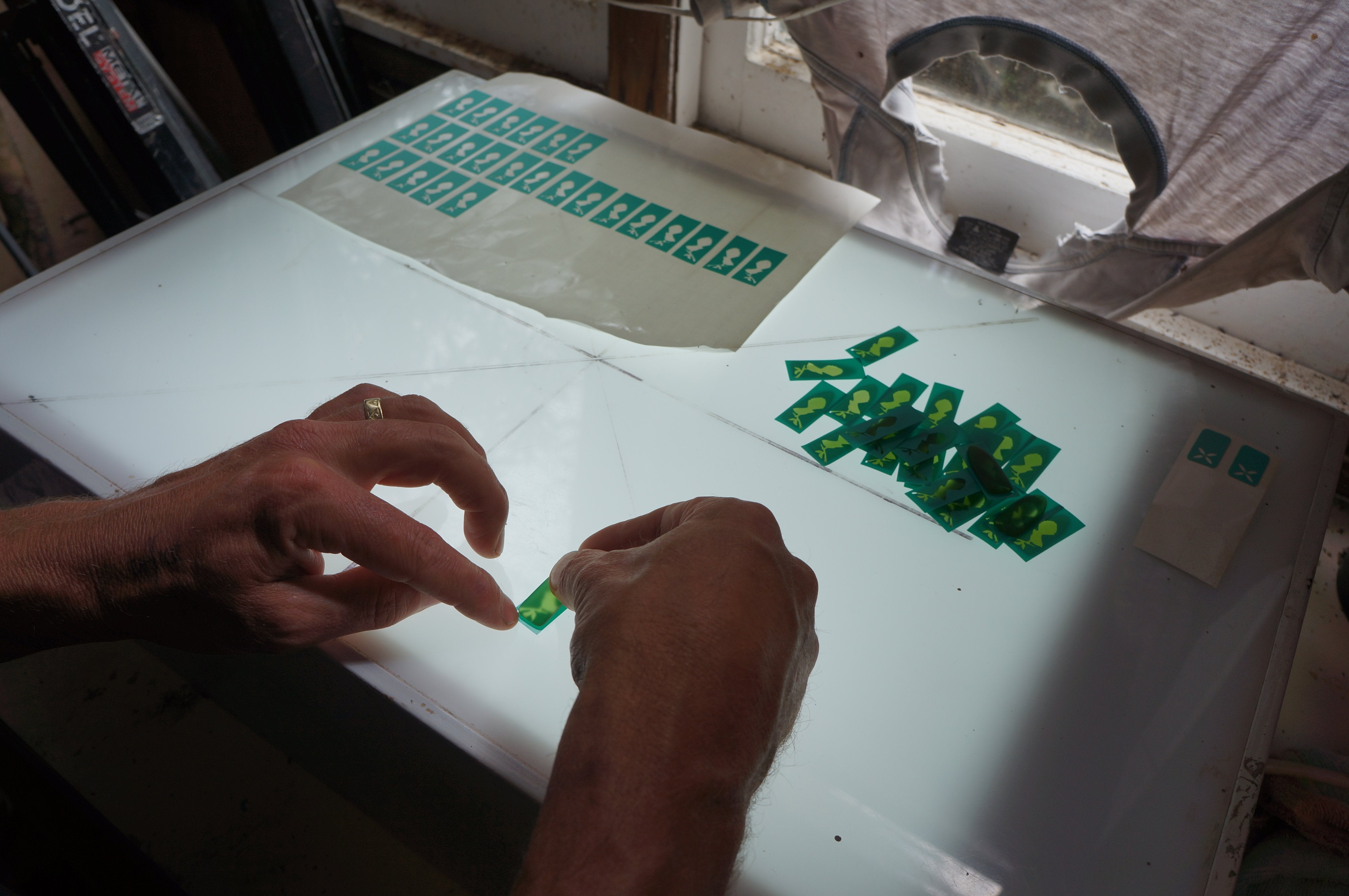 Sandblast resist stickers are put on the blanks cut from a wine bottle.